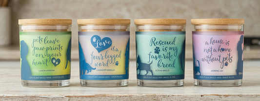 Four candles with motivational phrases on labels, placed on a wooden surface.